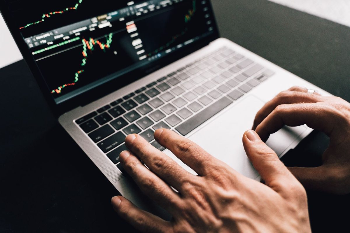 A laptop screen showing a rising stock market chart