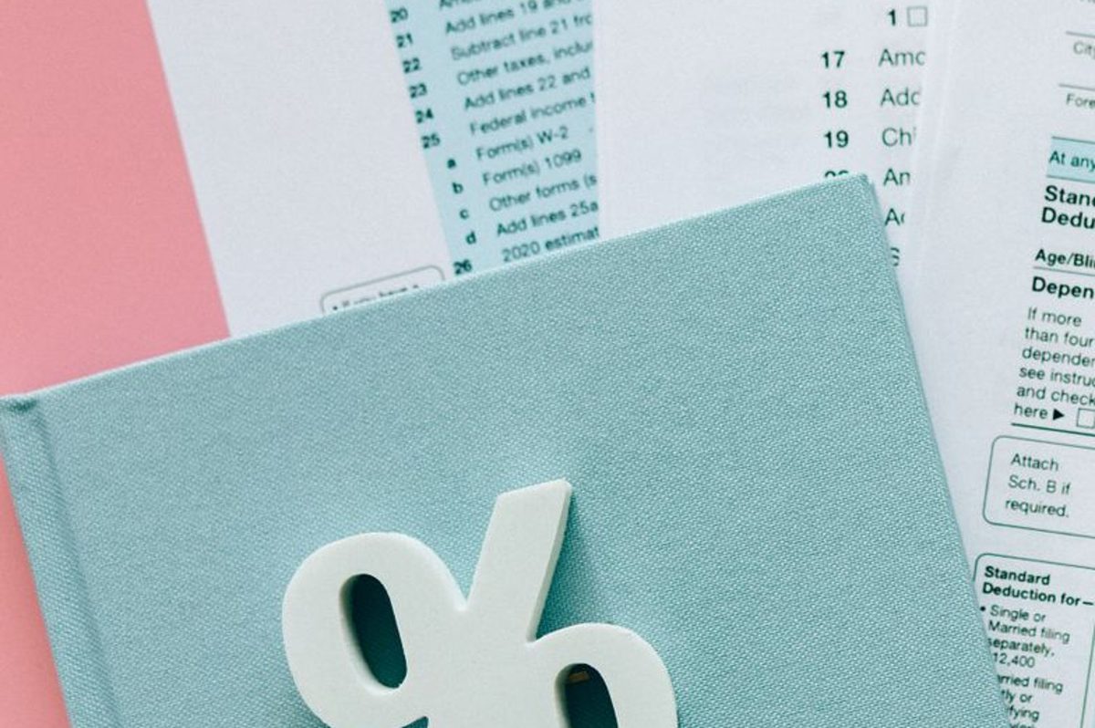 A percentage symbol resting on tax paperwork
