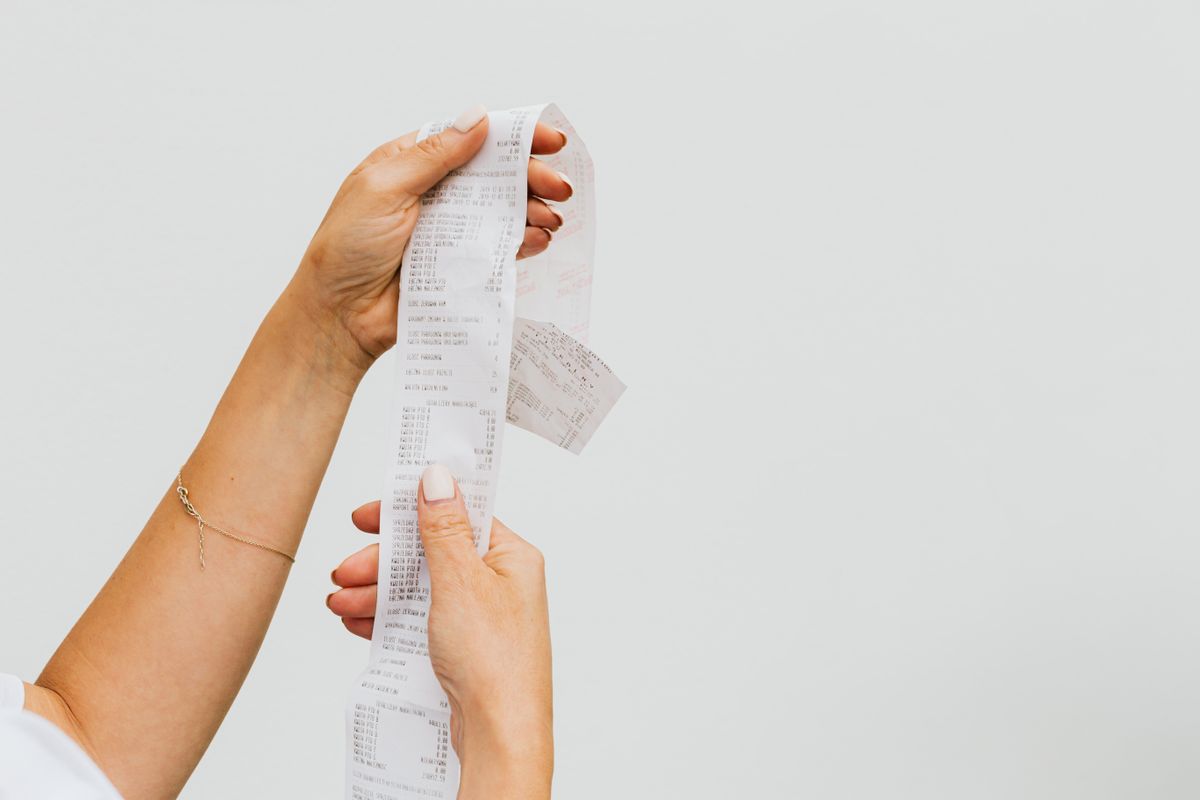 Two hands unfurling a very long till receipt