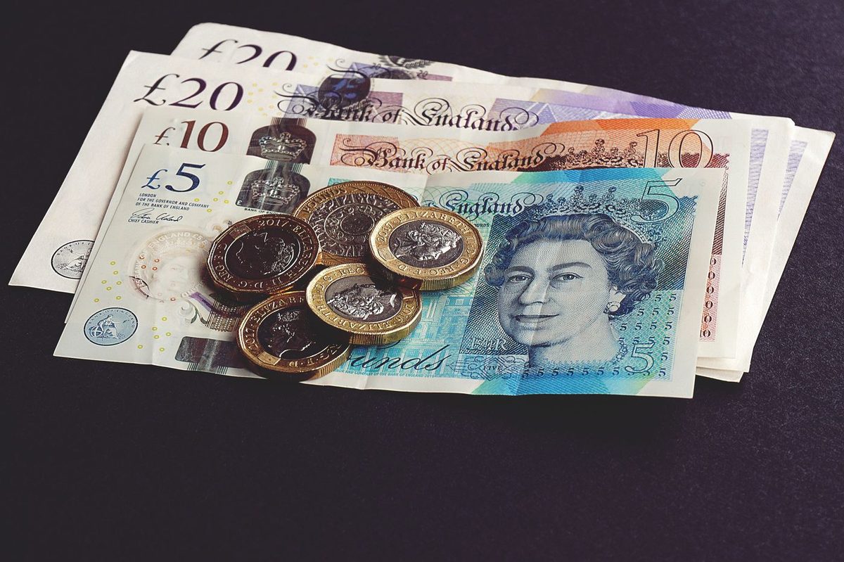 British banknotes and pound coins on a dark surface