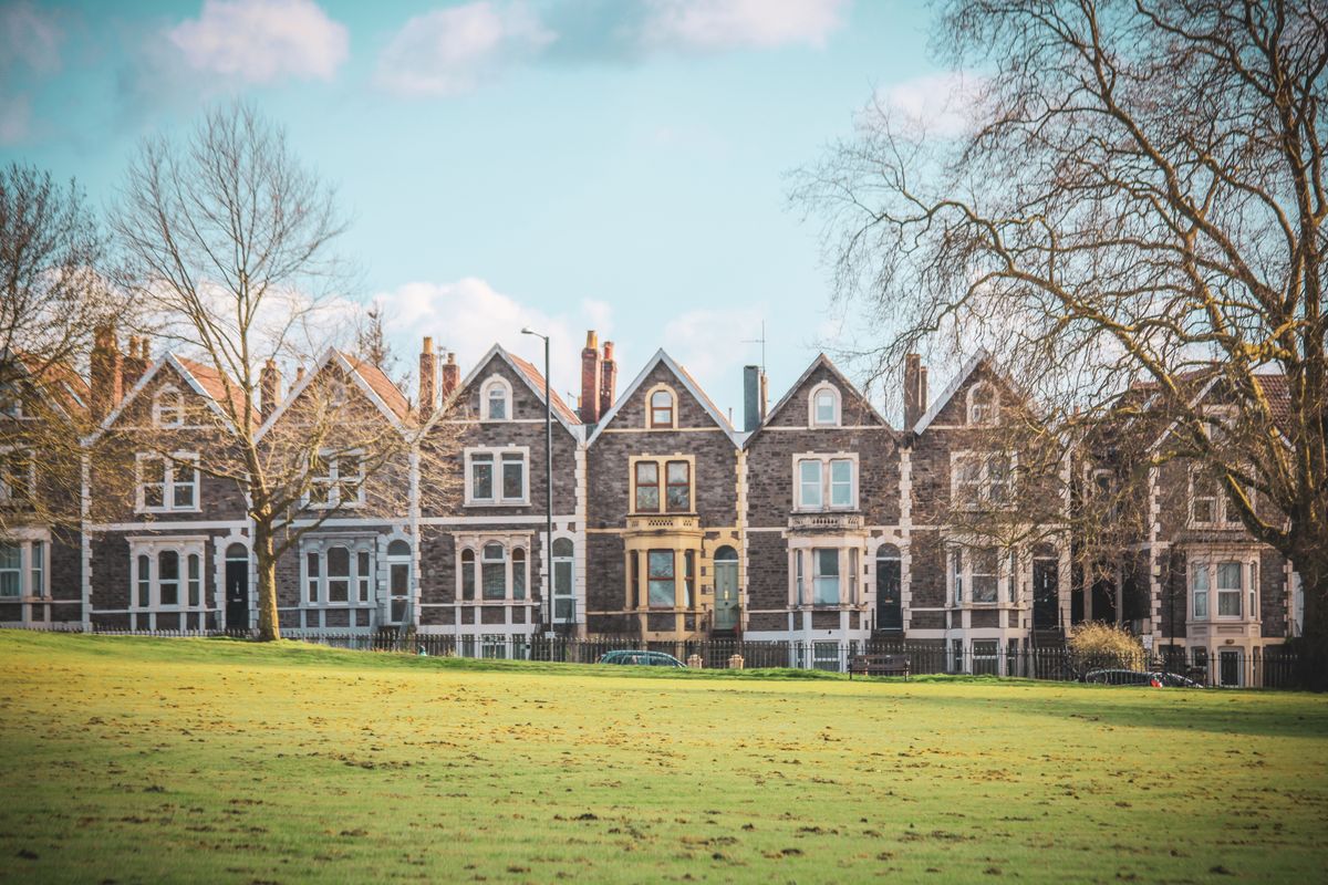 A row of British Victorian terraced houses seen across parkland